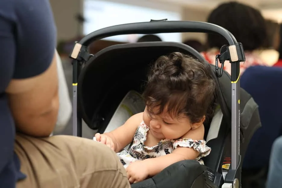A baby accompanied during a gathering